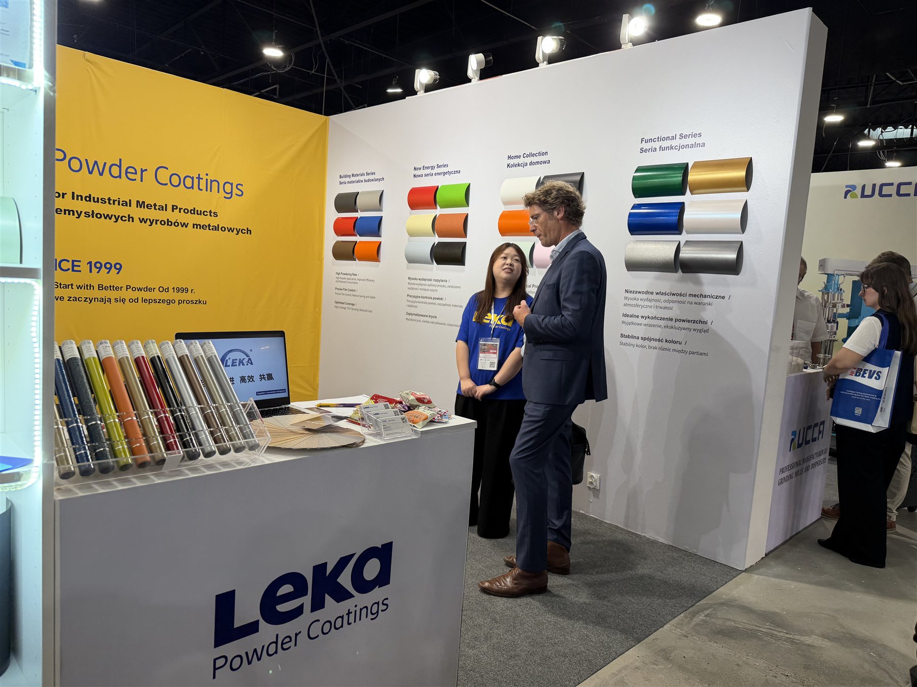 Leka team discussing powder coating samples with a visitor in Poland